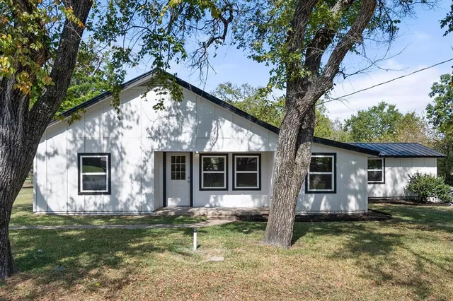 a view of a house with backyard and a tree