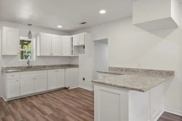 a kitchen with granite countertop a sink and cabinets