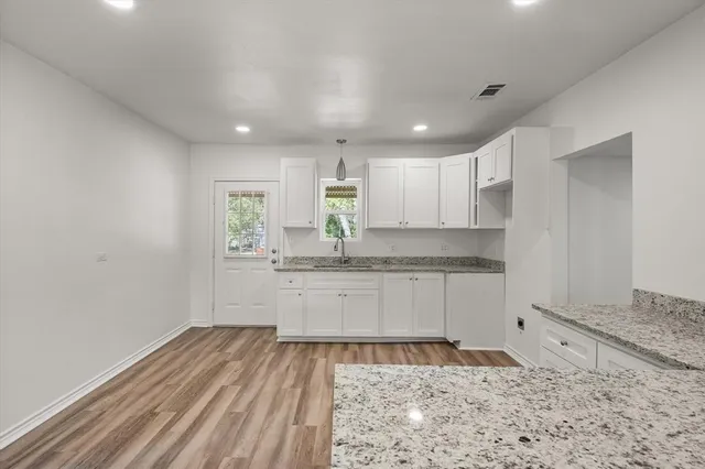 a kitchen with granite countertop white cabinets and white appliances