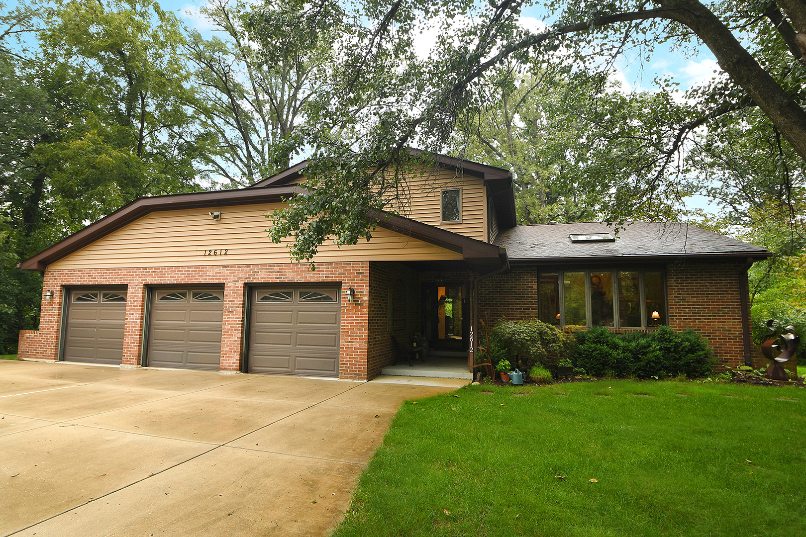 a front view of a house with a garden and plants