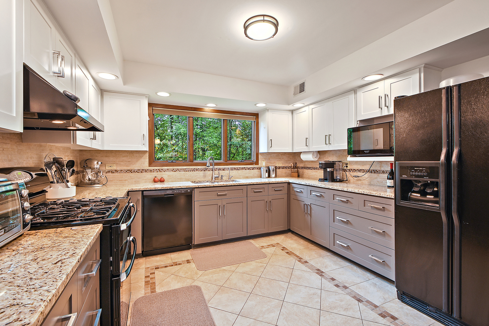 12612 West Hadley Road Homer Glen, IL 60491 - Photo 9 of 39 a kitchen with stainless steel appliances granite countertop a stove top oven a sink dishwasher a refrigerator and a dining table with wooden floor