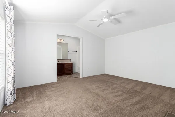 a spacious bedroom with a bed and a flat screen tv