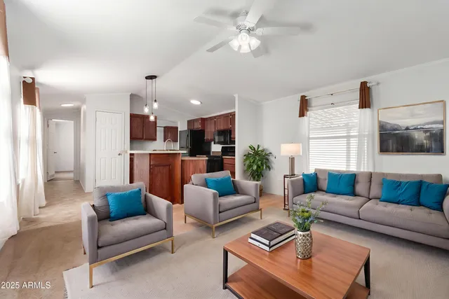 a living room with furniture kitchen view and a chandelier