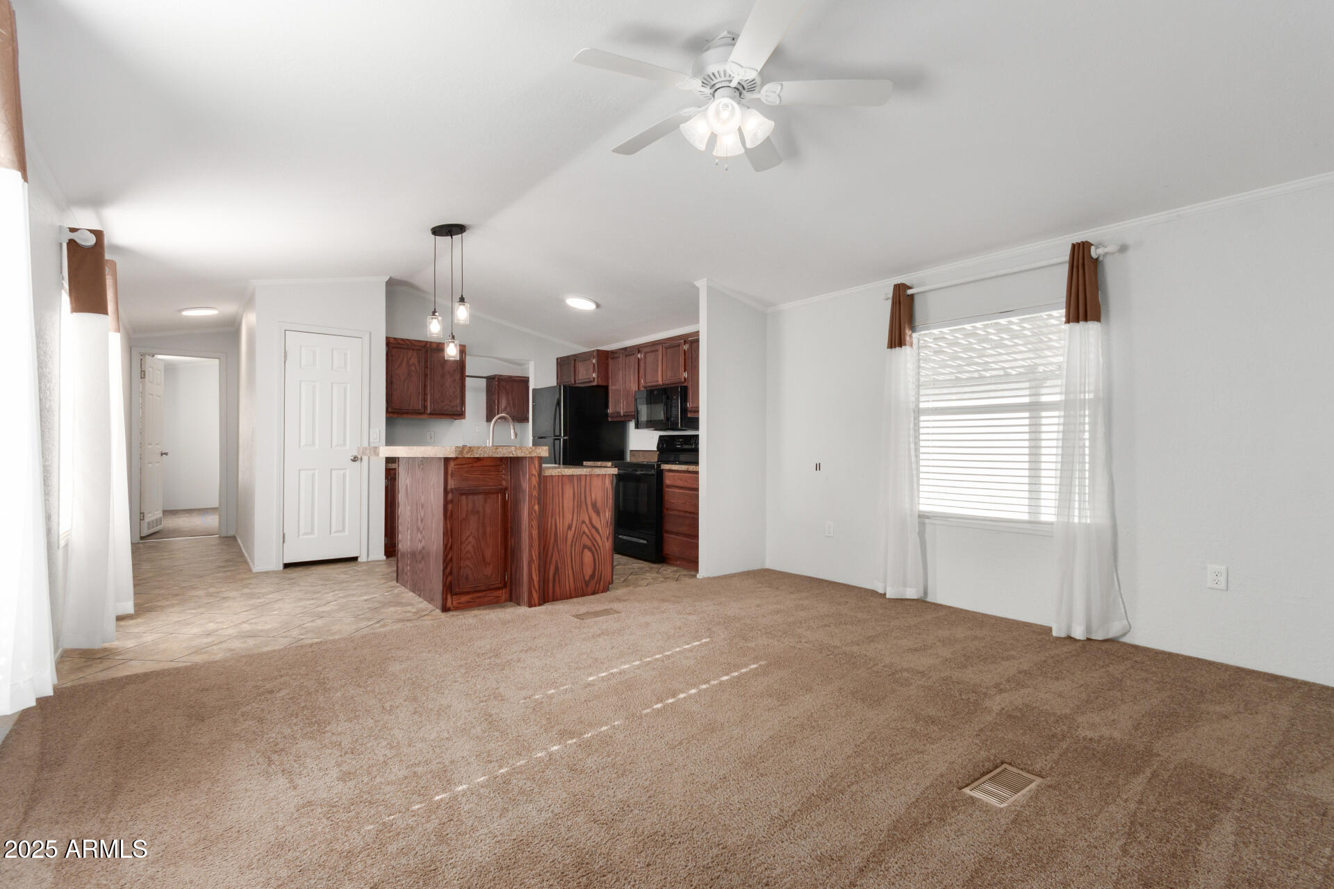 320 East McKellips Road, Unit 230 Mesa, AZ 85201 - Photo 7 of 43 a view of a kitchen with a stove cabinets a ceiling fan and wooden floor