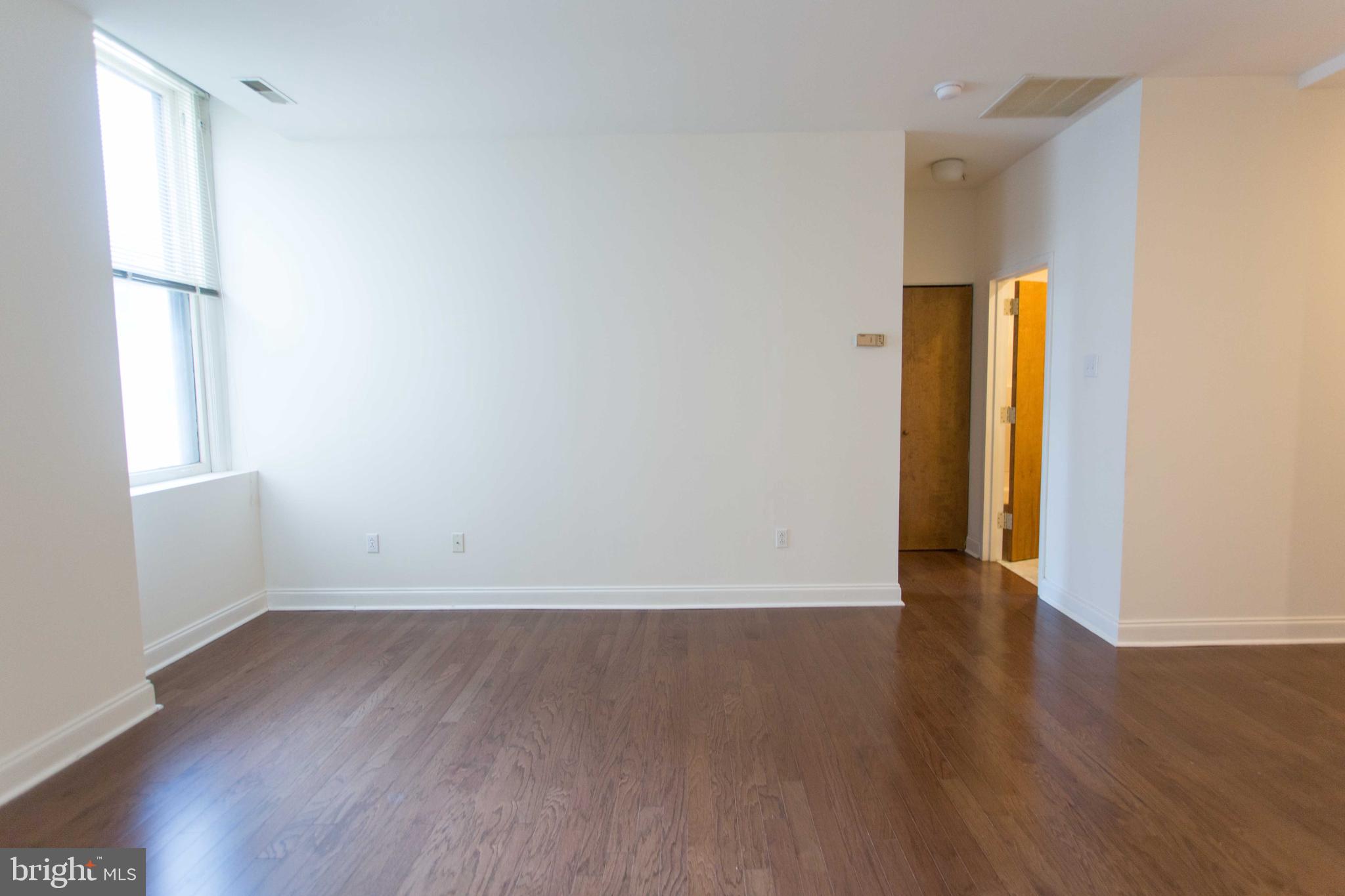 1600-2 Walnut Street, Unit 405 Philadelphia, PA 19103 - Photo 13 of 22 an empty room with wooden floor and windows