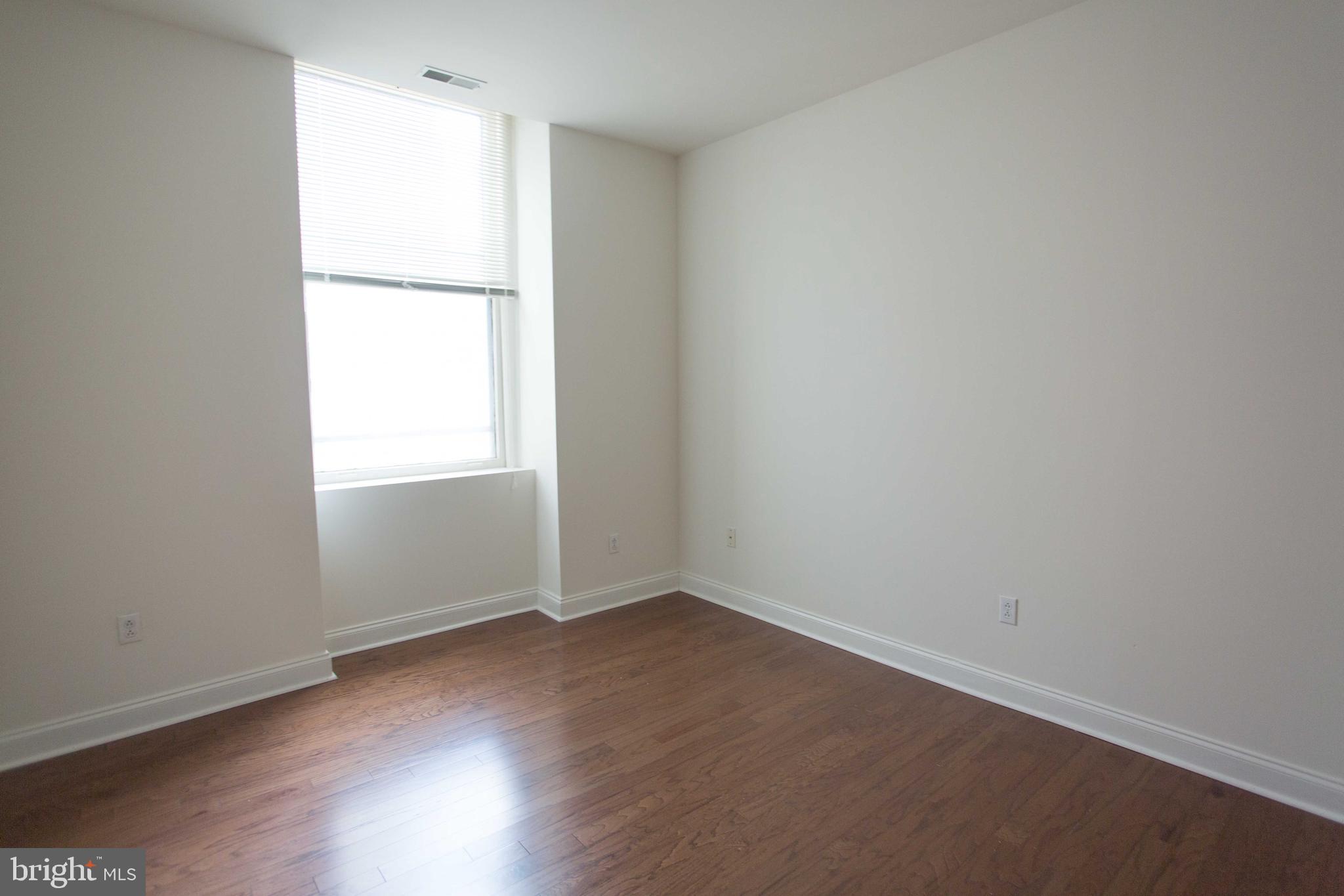 1600-2 Walnut Street, Unit 405 Philadelphia, PA 19103 - Photo 19 of 22 an empty room with wooden floor and windows