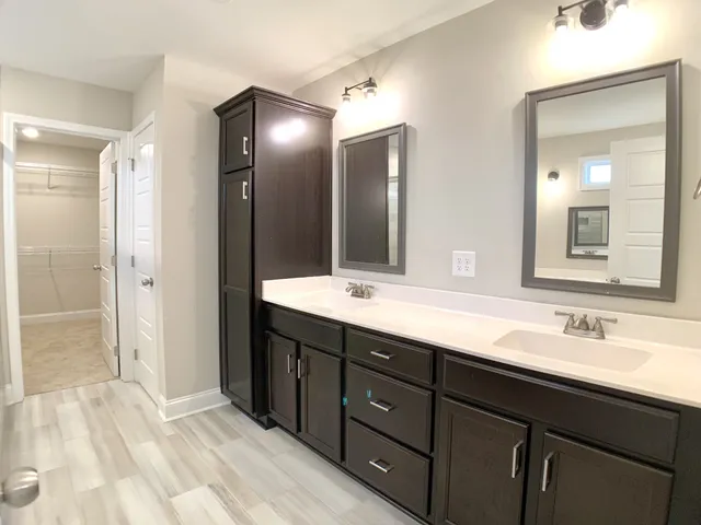 a bathroom with double vanity sinks and a mirror
