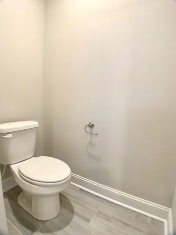 a white toilet sitting next to a white wall