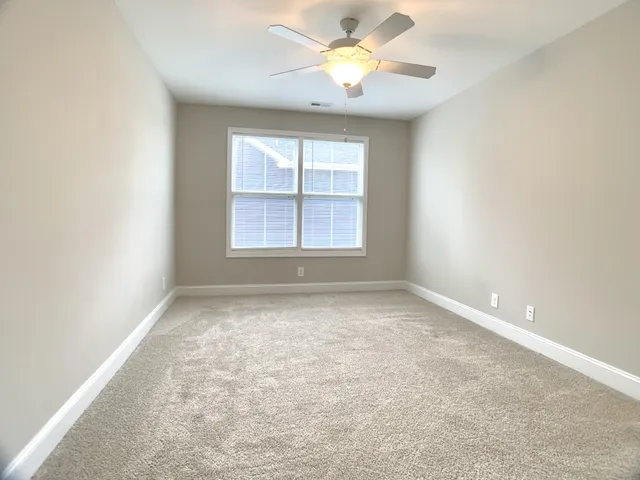 an empty room with a window and a fan