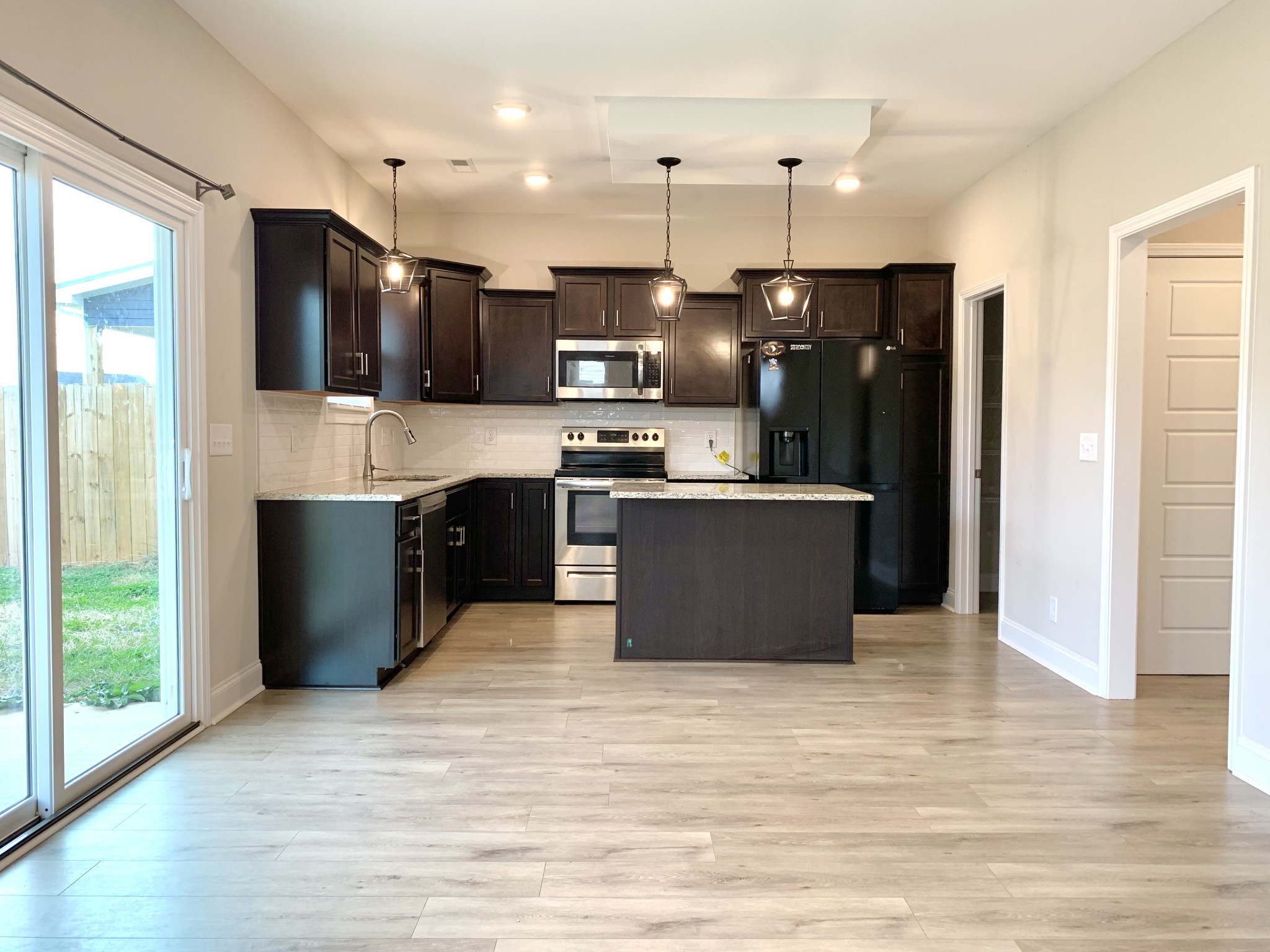 208 Copeland Road Clarksville, TN 37042 - Photo 7 of 35 a kitchen with kitchen island a refrigerator and a stove top oven