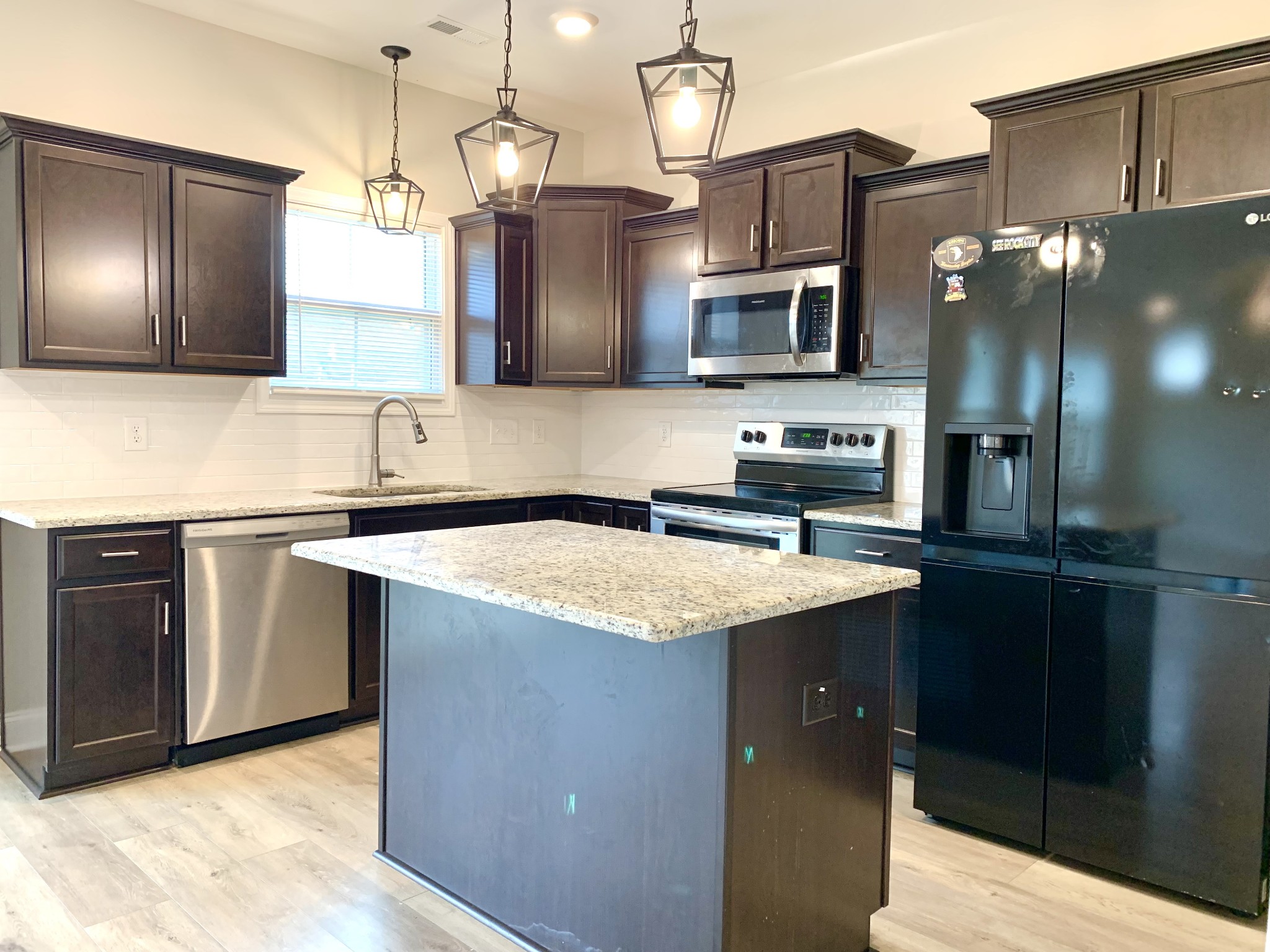 208 Copeland Road Clarksville, TN 37042 - Photo 9 of 35 a kitchen with stainless steel appliances granite countertop a sink a microwave and wooden cabinets