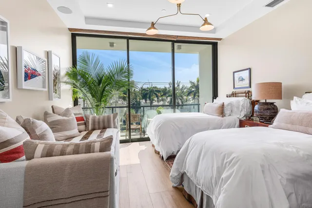 a bed room with two large bed and a large window