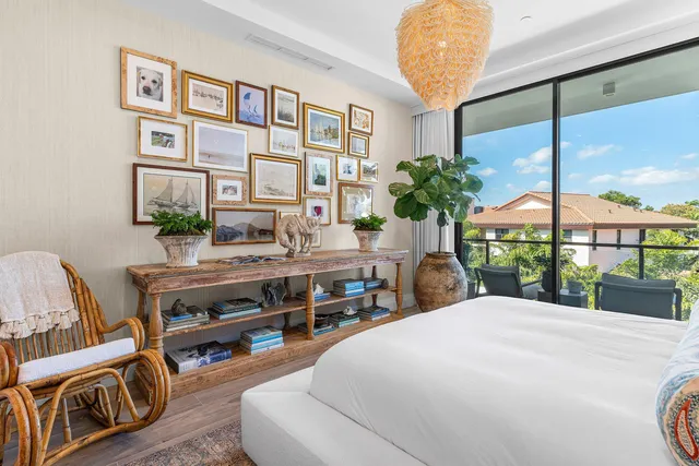 a bedroom with a bed table and a large window
