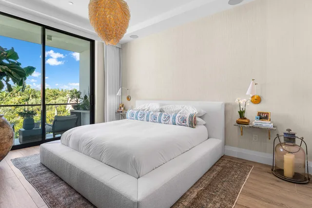 a bedroom with a bed a window and potted plant