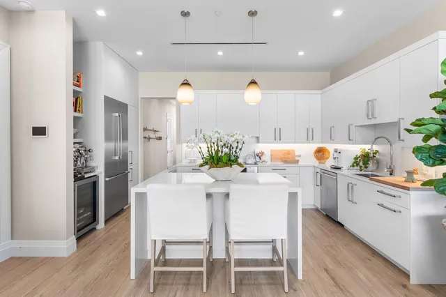a kitchen with white cabinets and stainless steel appliances
