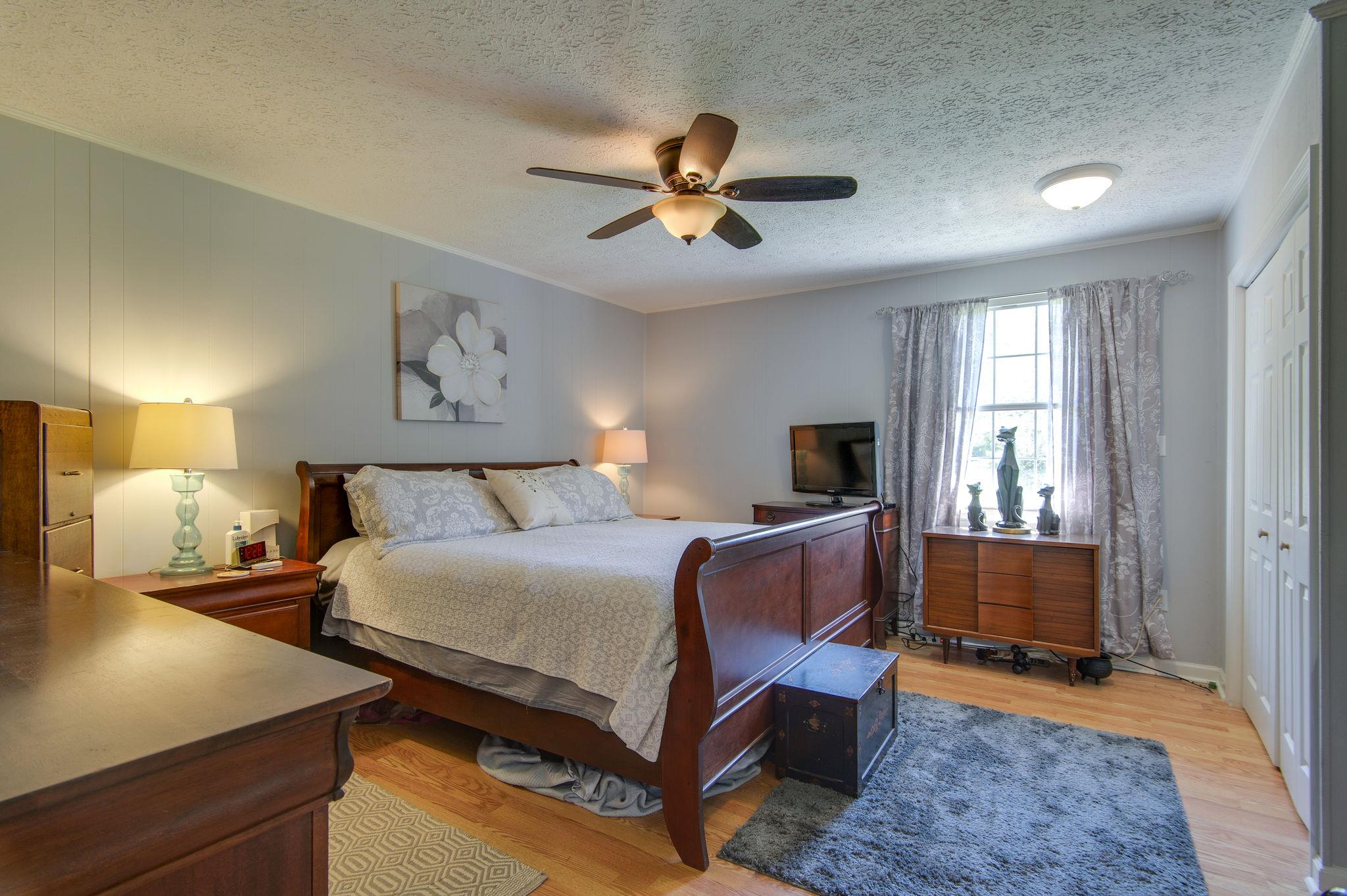7116 Crow Cut Road Fairview, TN 37062 - Photo 15 of 30 a bedroom with a bed and a chandelier