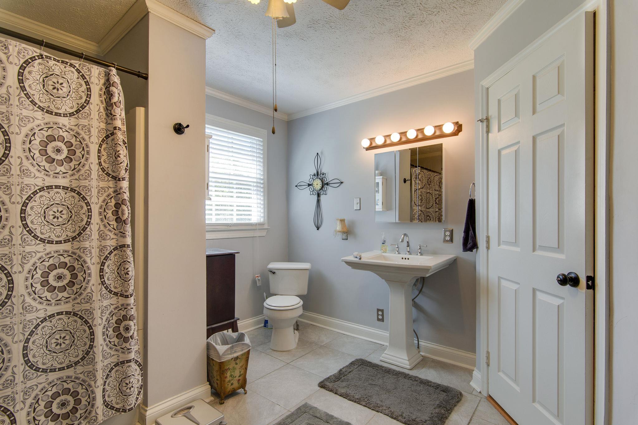 7116 Crow Cut Road Fairview, TN 37062 - Photo 18 of 30 a bathroom with a toilet sink and mirror