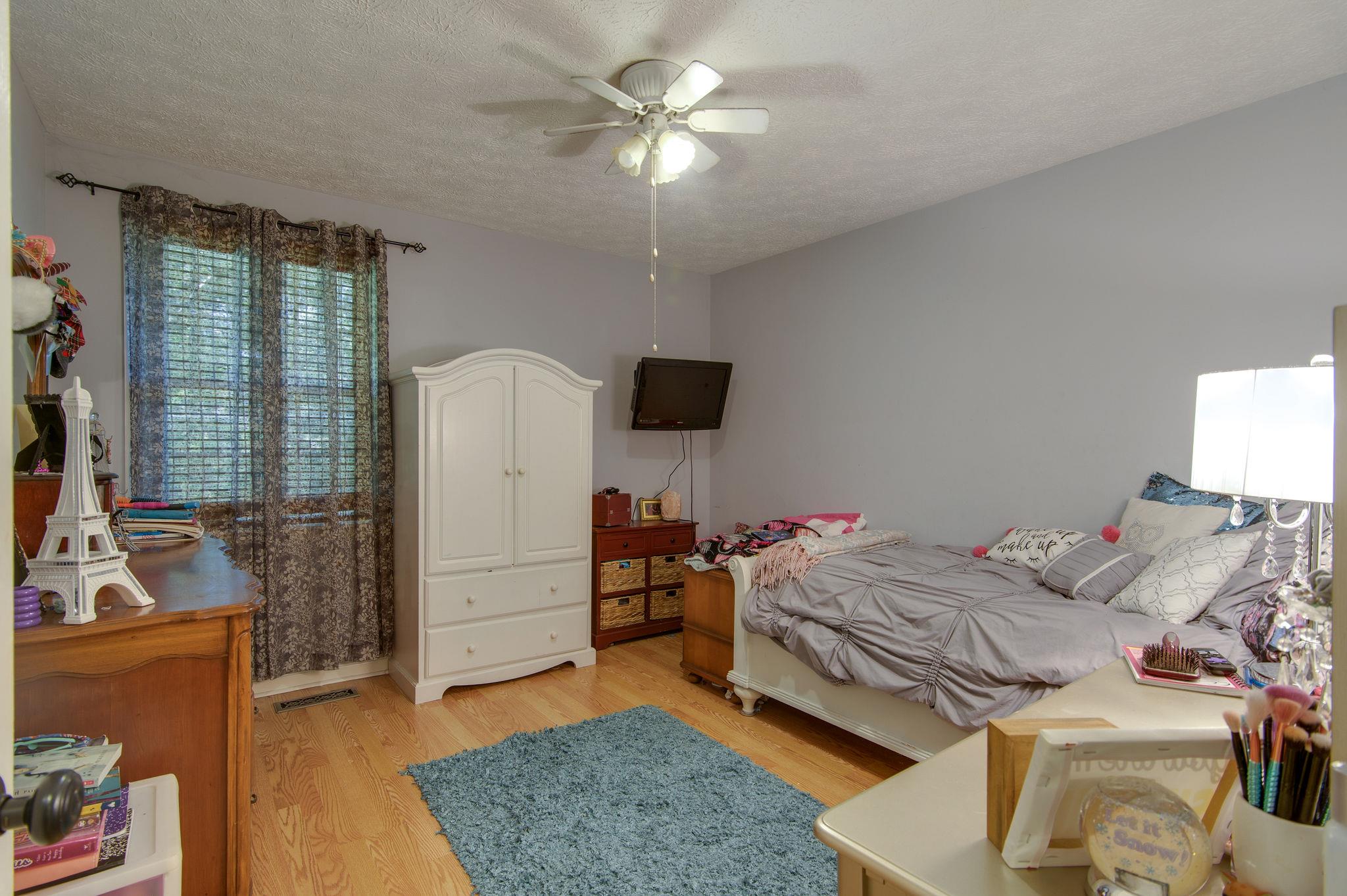 7116 Crow Cut Road Fairview, TN 37062 - Photo 20 of 30 a bedroom with a bed and a chandelier