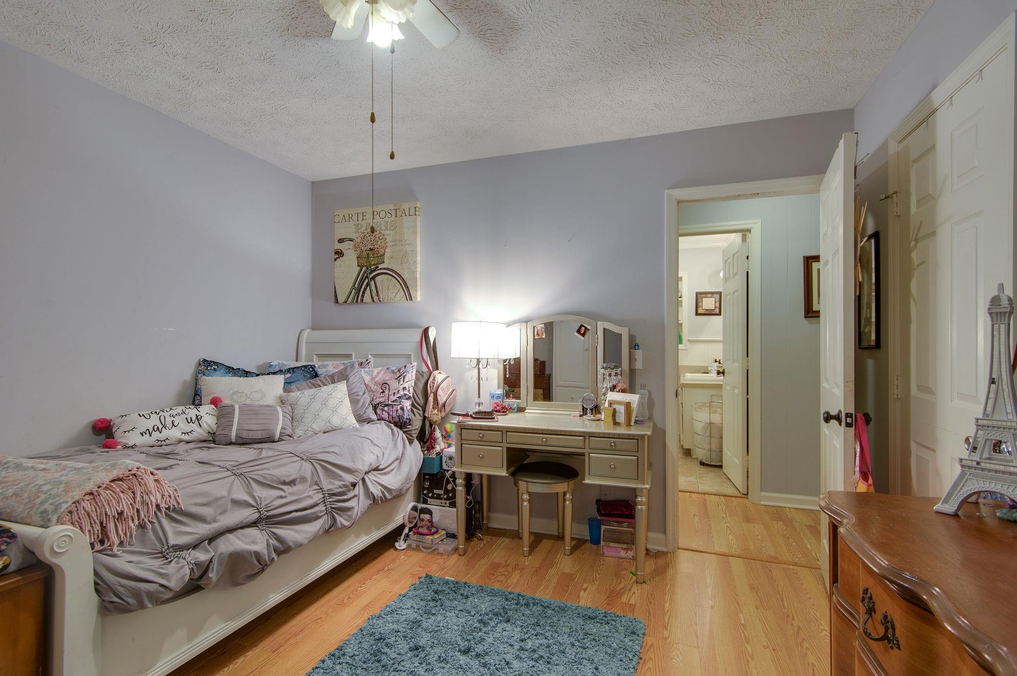 7116 Crow Cut Road Fairview, TN 37062 - Photo 21 of 30 a bedroom with a bed and a chandelier