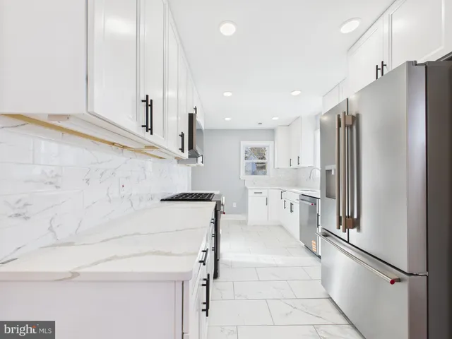 a kitchen with stainless steel appliances white cabinets and a sink