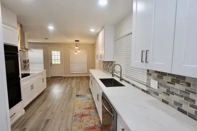 a kitchen with granite countertop a sink and a stove top oven
