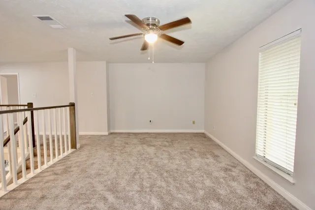a view of a livingroom with a ceiling fan and window