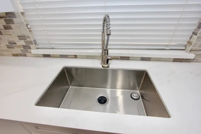 an empty room with wooden floor fireplace and windows