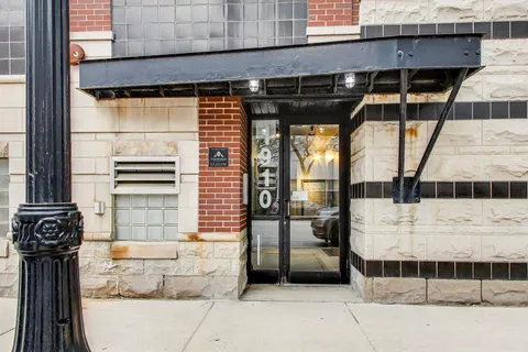a view of a front door and car parked