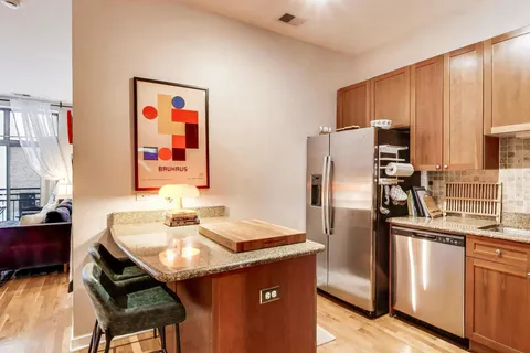 a kitchen with stainless steel appliances a sink stove refrigerator and cabinets