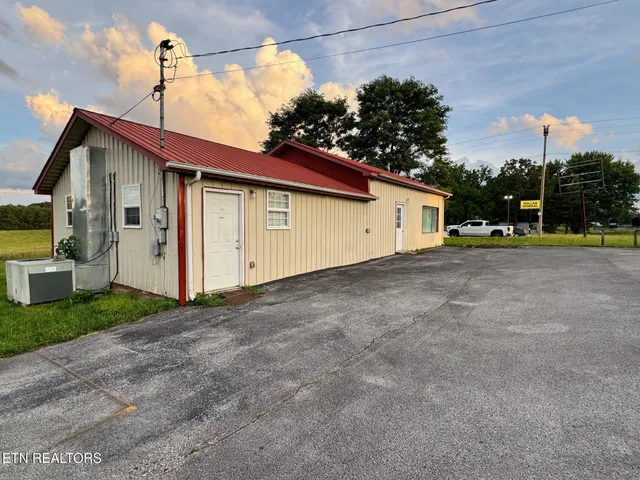 a view of a house with a backyard and basketball court