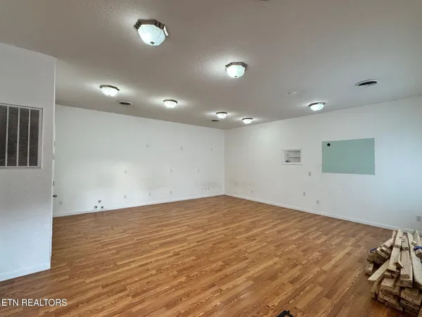 a view of empty room with wooden floor