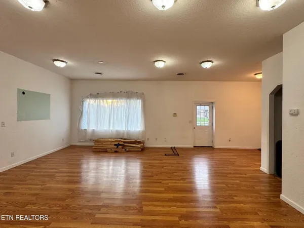 a view of empty room with wooden floor
