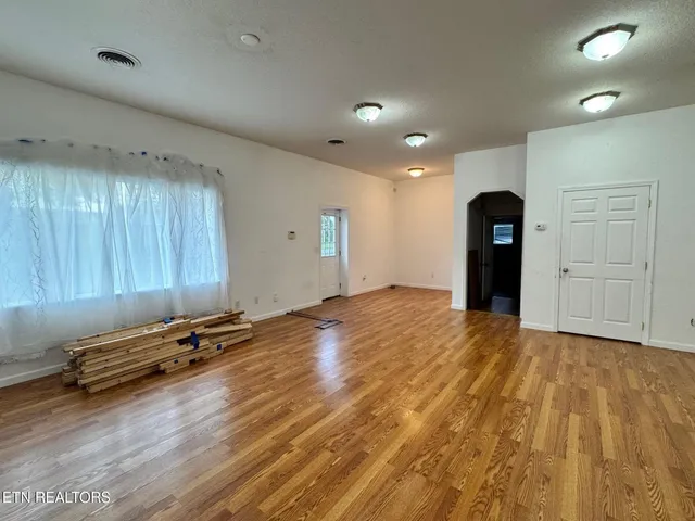 a view of a room with gym equipment and wooden floor
