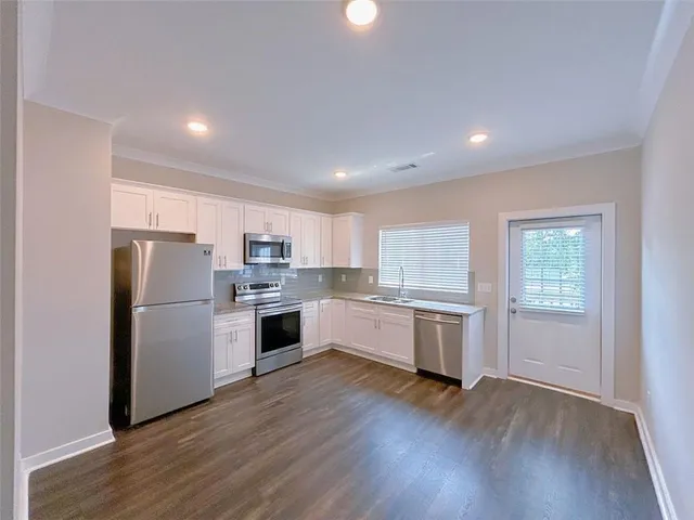 a kitchen with a refrigerator and white cabinets