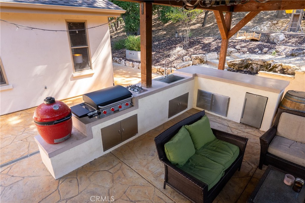 6360 Navarette Avenue Atascadero, CA 93422 - Photo 70 of 75 There is a large island with cement countertops, burners, sink and beverage fridge.