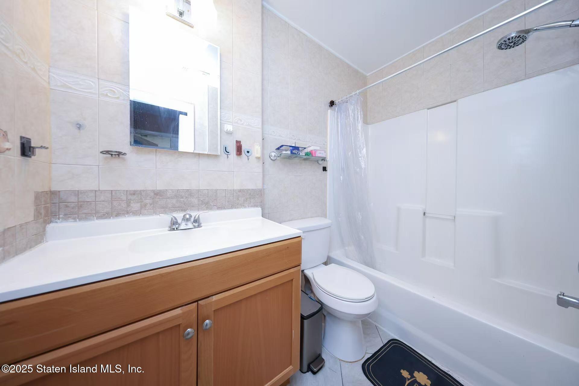78 Emily Lane Staten Island, NY 10312 - Photo 11 of 24 a bathroom with a sink a toilet and a bathtub