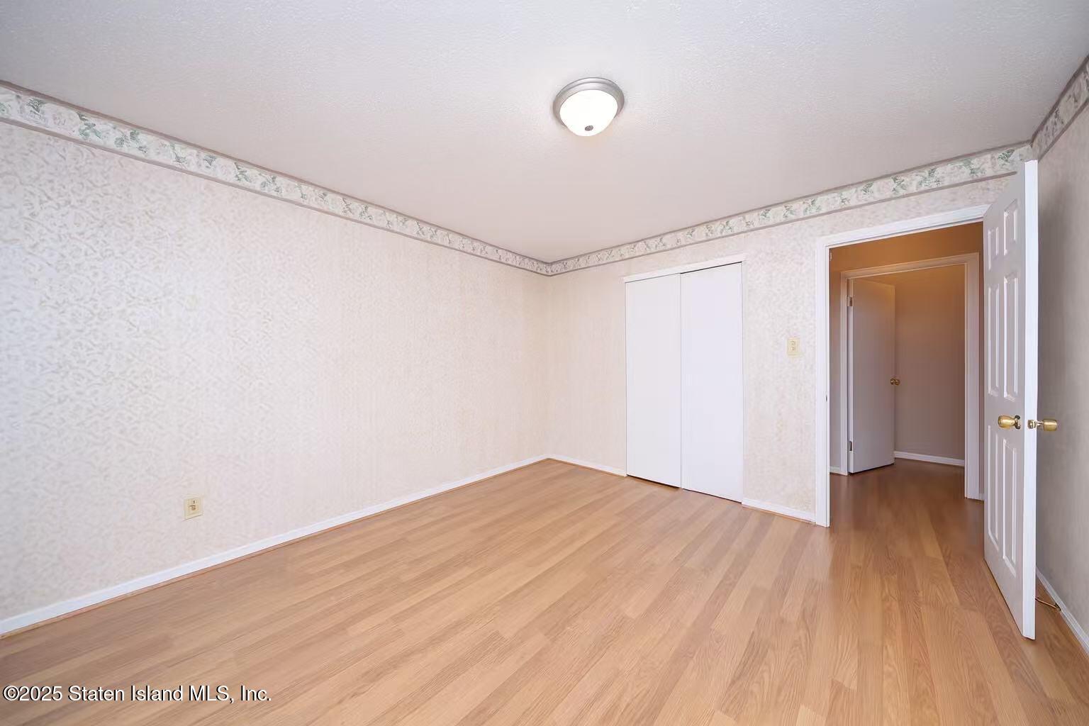 78 Emily Lane Staten Island, NY 10312 - Photo 19 of 24 a view of a room with wooden floor and white walls