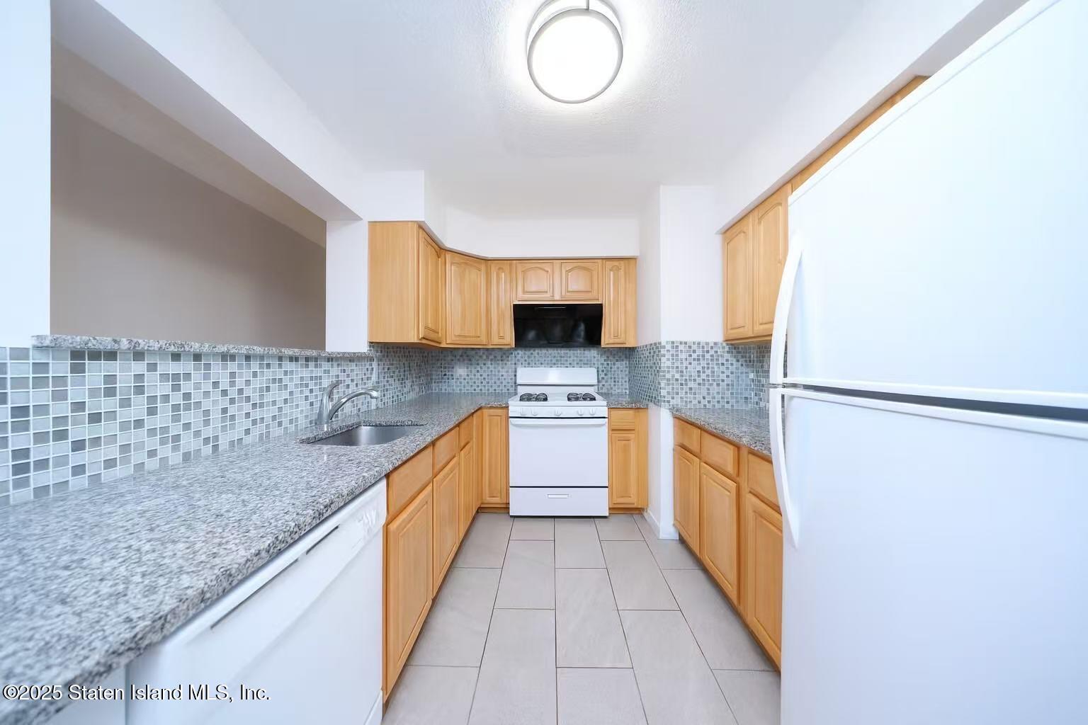 78 Emily Lane Staten Island, NY 10312 - Photo 6 of 24 a large kitchen with kitchen island granite countertop a sink and a stove top oven