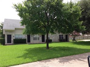 a front view of a house with a garden and trees