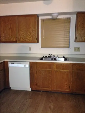 a view of kitchen with wooden floor and cabinets