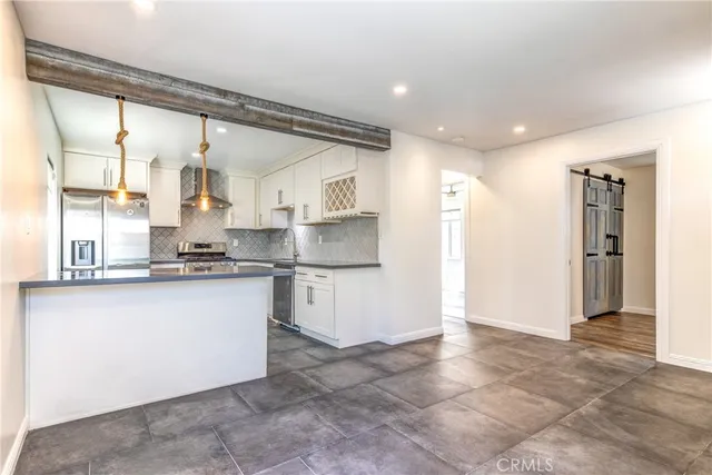 a kitchen with stainless steel appliances granite countertop a refrigerator and a sink