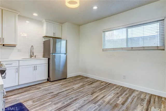 a kitchen with a refrigerator sink and cabinets