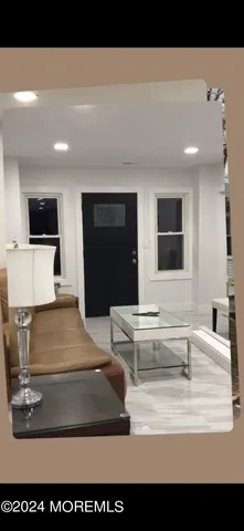 a living room with a couch and a dining table with wooden floor