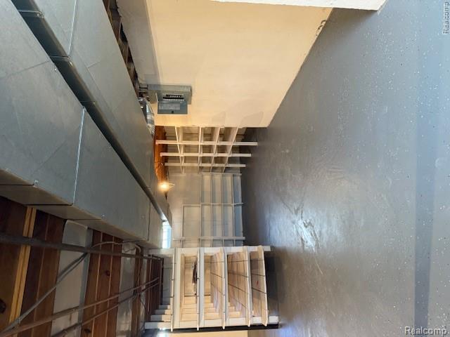 43038 Hanford Road Canton, MI 48187 - Photo 34 of 36 Utility space featuring exposed ductwork, open ceiling joists, painted concrete flooring, and built-in shelving units