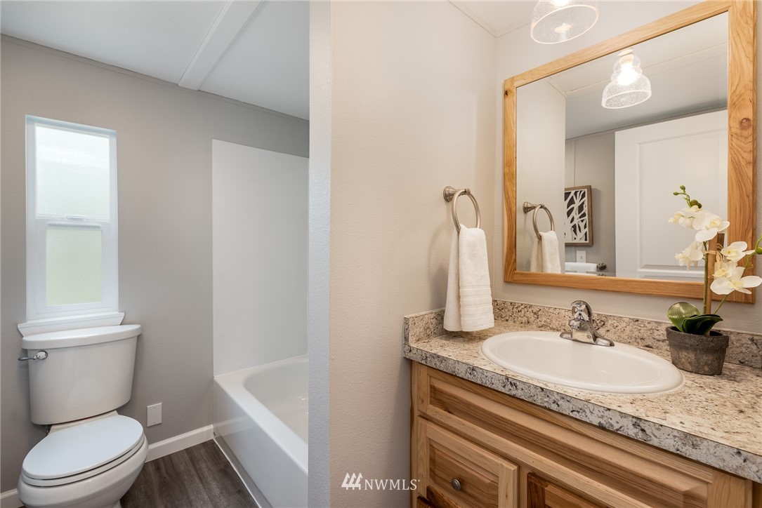 7992 Ham Road Custer, WA 98240 - Photo 18 of 31 a bathroom with a granite countertop sink a toilet and a mirror