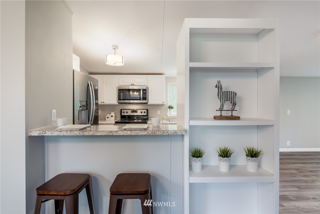 7992 Ham Road Custer, WA 98240 - Photo 7 of 31 a kitchen with stainless steel appliances a table and chairs in it
