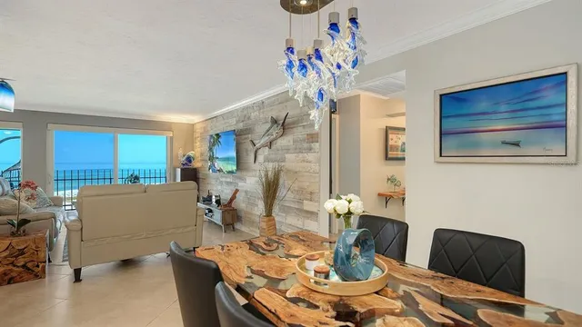 a kitchen with stainless steel appliances kitchen island granite countertop a sink a stove a dining table and chairs