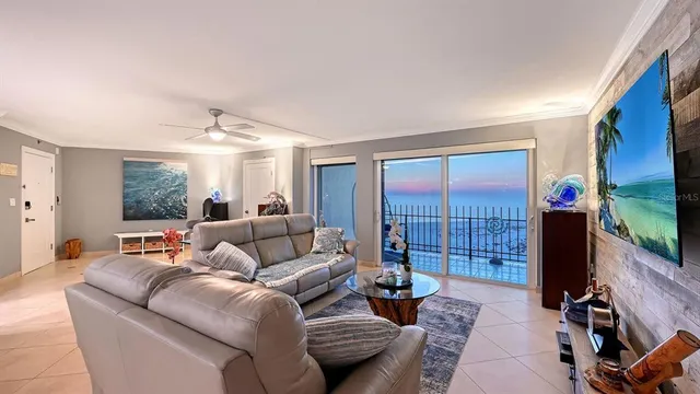 a living room with furniture a ceiling fan a fireplace and a large window