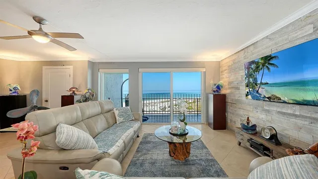 a living room with furniture a floor to ceiling window and a flat screen tv