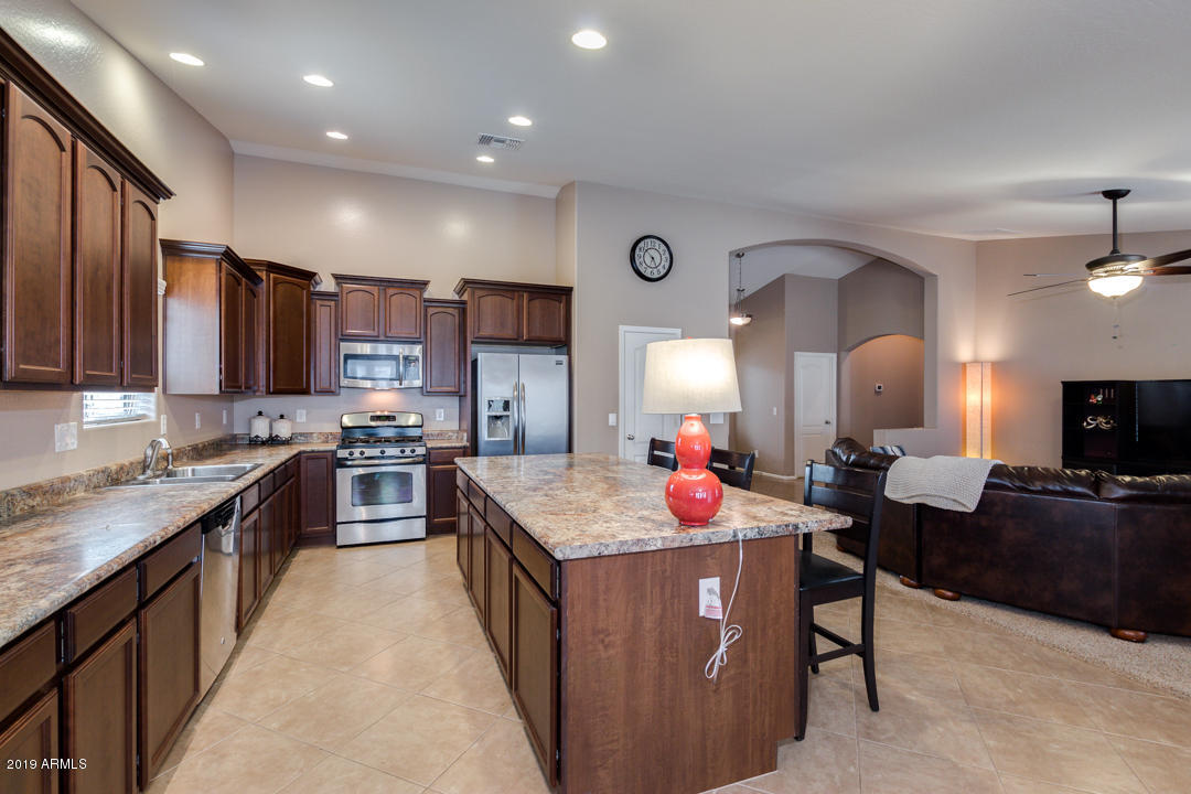 17776 West Charter Oak Road Surprise, AZ 85388 - Photo 11 of 35 a kitchen with kitchen island granite countertop lots of counter top space a sink and appliances